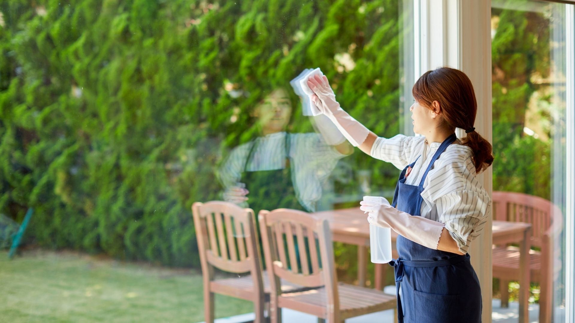 Women With Spray Bottle Wiping Window